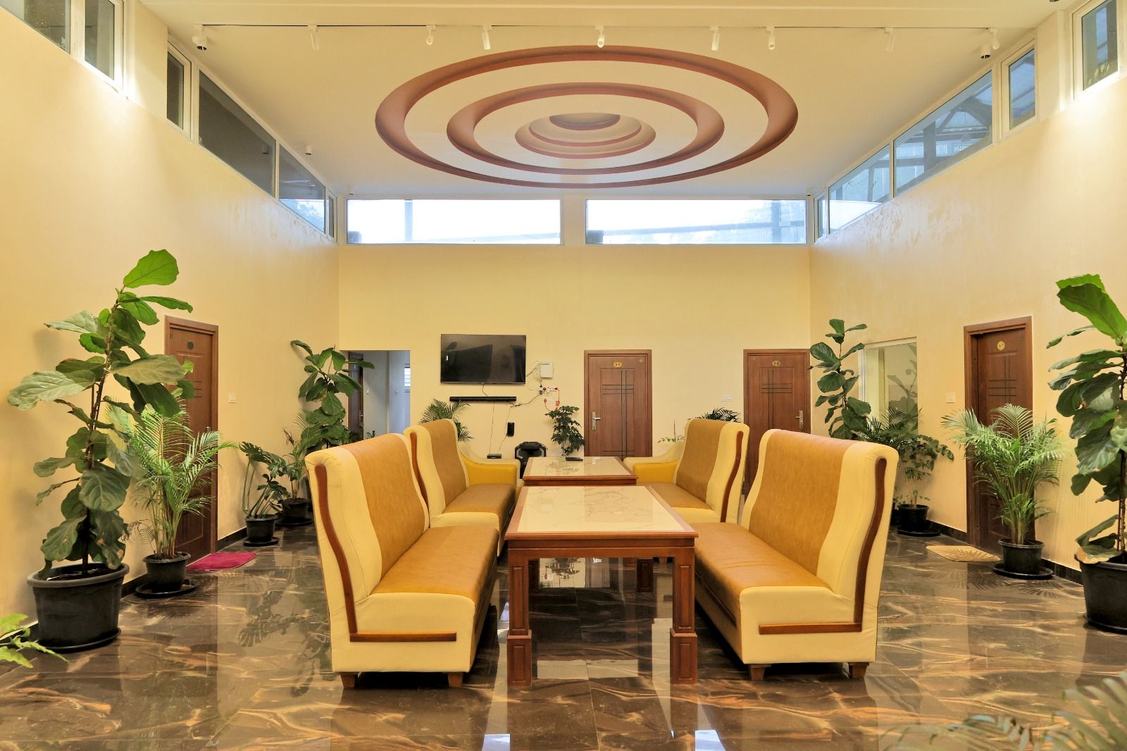 Glass atrium lobby with spiral ceiling feature, plants and lounge seating