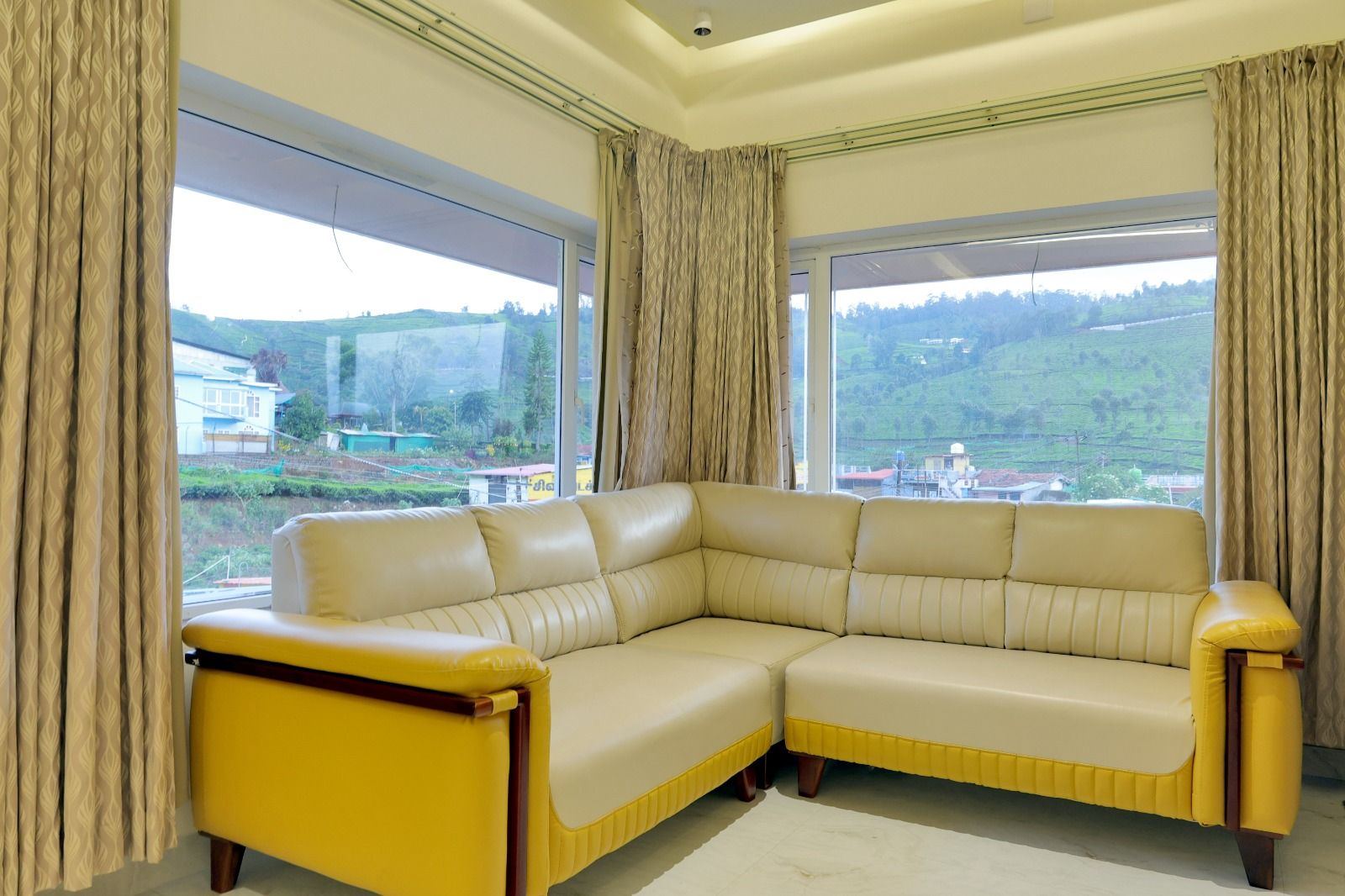 Lounge with corner sofa and panoramic windows overlooking Nilgiri tea gardens