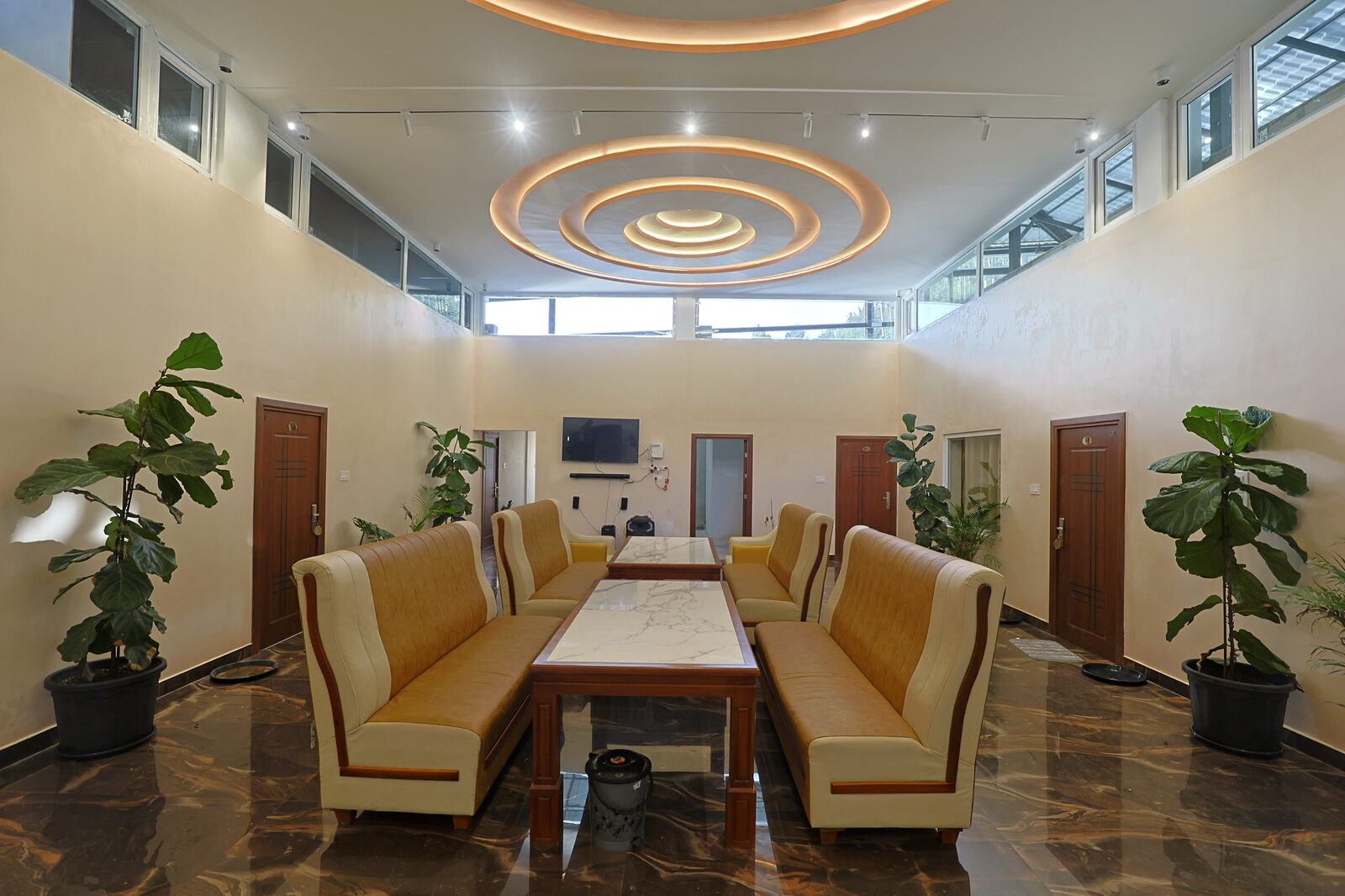 Double-height reception lounge with ringed ceiling coves and gold armchairs